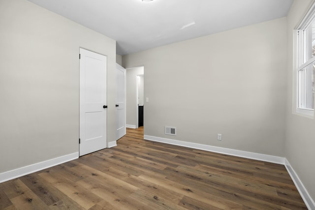 unfurnished bedroom with dark hardwood / wood-style flooring