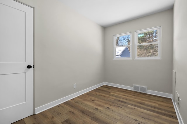 unfurnished room with dark hardwood / wood-style flooring