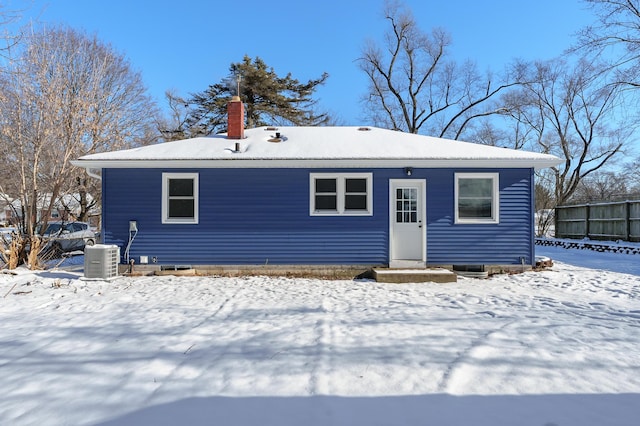 snow covered house with central air condition unit