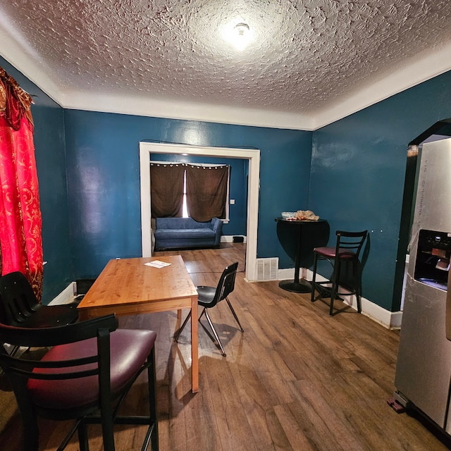 dining room featuring hardwood / wood-style flooring and a textured ceiling