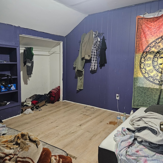 bedroom with lofted ceiling and wood-type flooring