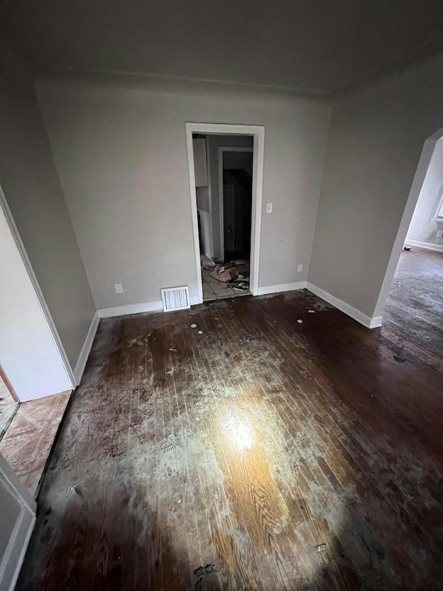 empty room with dark hardwood / wood-style flooring