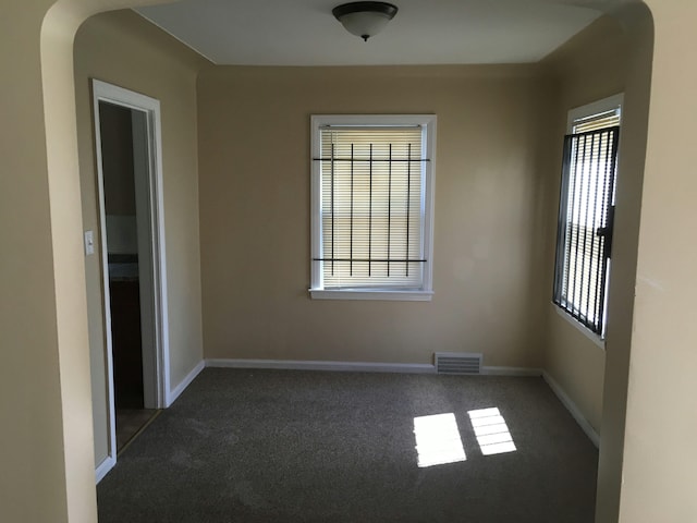 empty room with dark colored carpet