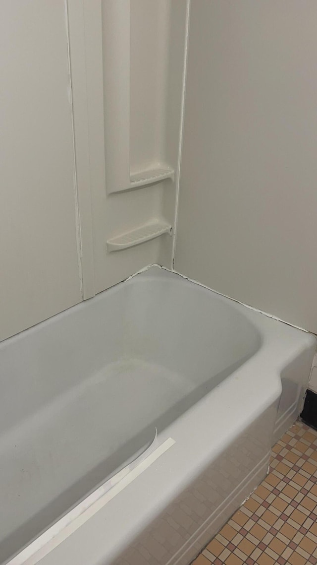 bathroom with tile patterned floors and a bathtub