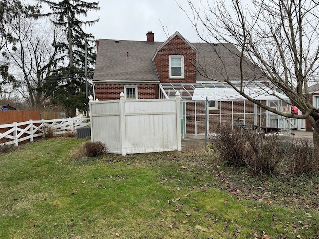 rear view of property featuring an outbuilding and a lawn