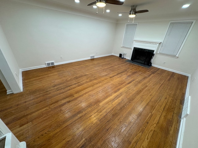 unfurnished living room featuring ceiling fan and hardwood / wood-style floors