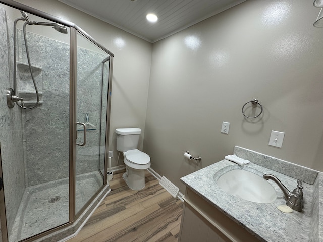 bathroom featuring walk in shower, vanity, toilet, and wood-type flooring