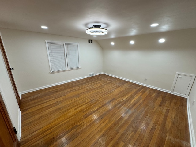 empty room with lofted ceiling and dark wood-type flooring