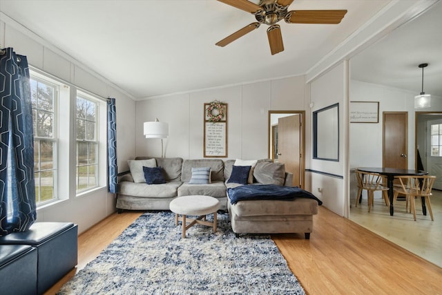 living room featuring lofted ceiling, hardwood / wood-style floors, ornamental molding, and ceiling fan