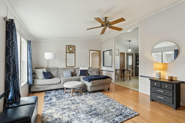 living room featuring ornamental molding, lofted ceiling, ceiling fan, and light hardwood / wood-style floors