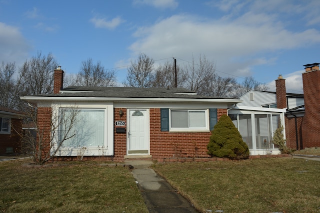 view of front of house featuring a front yard and a sunroom