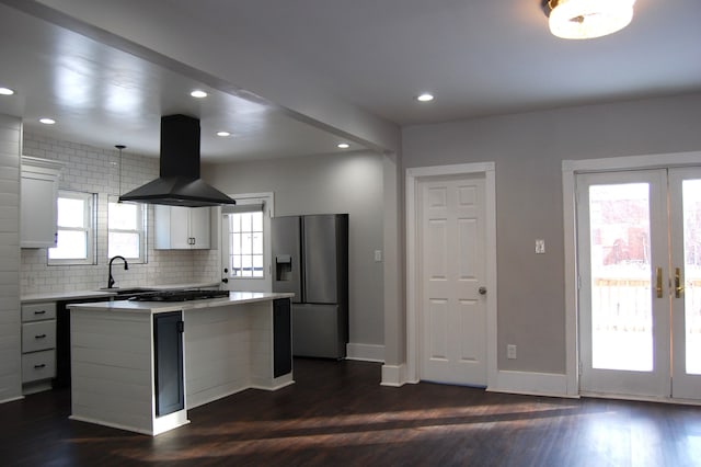 kitchen with french doors, a kitchen island, island exhaust hood, stainless steel appliances, and white cabinets