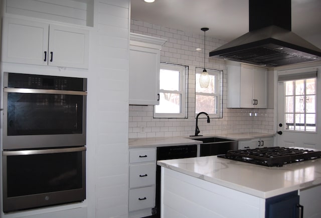 kitchen featuring sink, white cabinetry, gas cooktop, double oven, and island exhaust hood