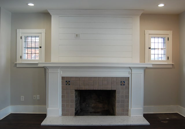 details with a tiled fireplace and hardwood / wood-style floors