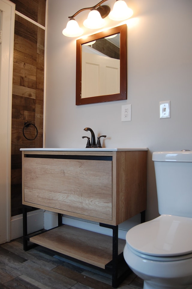 bathroom with wood-type flooring, vanity, and toilet