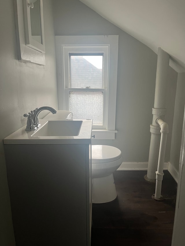 bathroom with vanity, hardwood / wood-style flooring, vaulted ceiling, and toilet