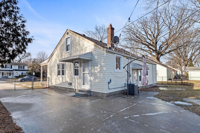 rear view of property with central AC