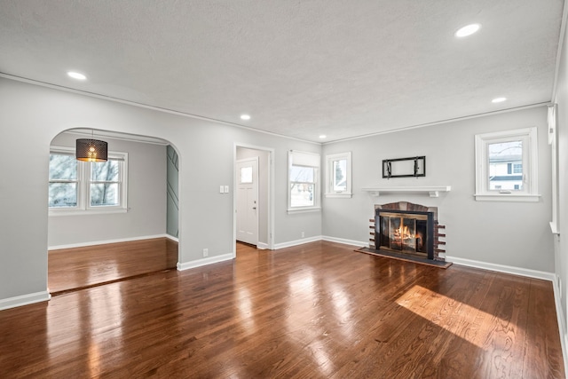 unfurnished living room featuring a textured ceiling, a fireplace, and dark hardwood / wood-style flooring