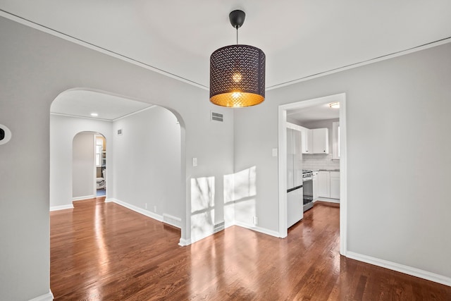 unfurnished dining area featuring crown molding and dark hardwood / wood-style flooring