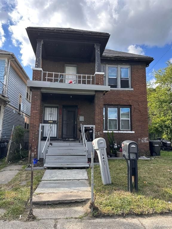 view of front of home with a balcony and a front yard