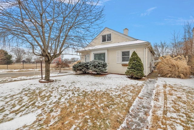 snow covered property featuring a chimney