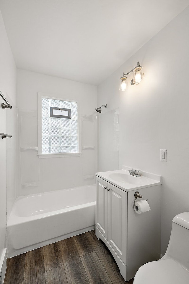 full bath with toilet, shower / bathing tub combination, wood finished floors, and vanity