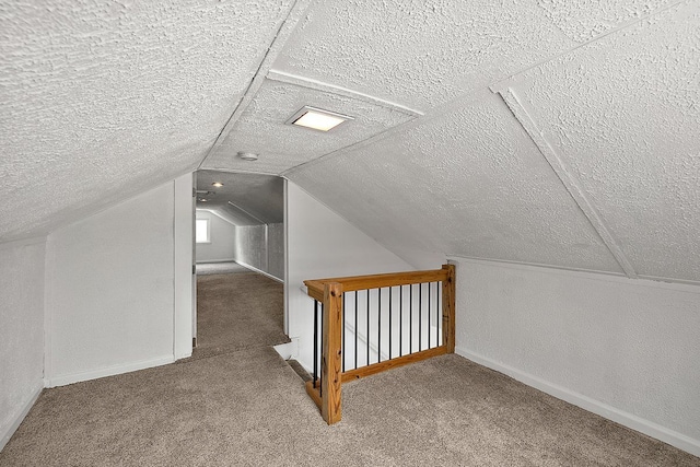 additional living space featuring carpet floors, lofted ceiling, and a textured ceiling