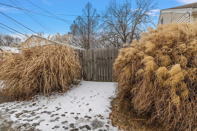 yard covered in snow featuring fence