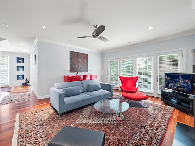 living room with hardwood / wood-style flooring, crown molding, and ceiling fan