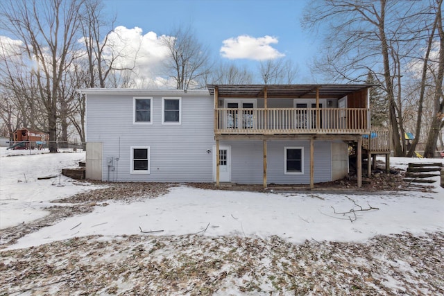 snow covered rear of property featuring a deck