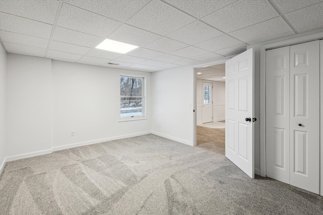 interior space with a paneled ceiling, carpet, and a wealth of natural light