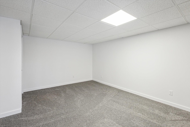 carpeted spare room with a drop ceiling