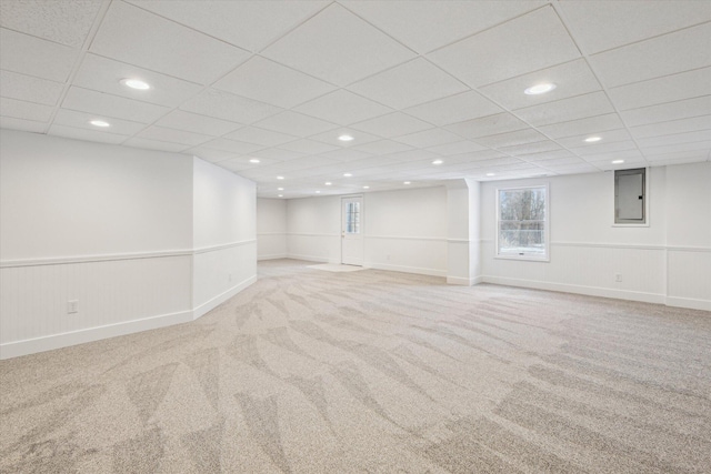 basement featuring light colored carpet and a paneled ceiling