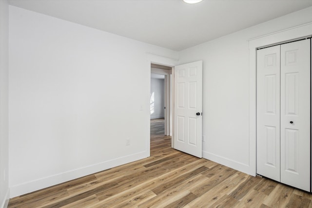 unfurnished bedroom featuring light hardwood / wood-style floors and a closet