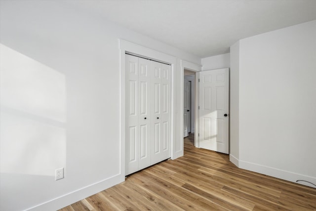 unfurnished bedroom featuring light hardwood / wood-style floors and a closet