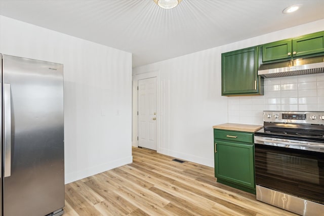 kitchen featuring stainless steel appliances, green cabinets, decorative backsplash, and light wood-type flooring