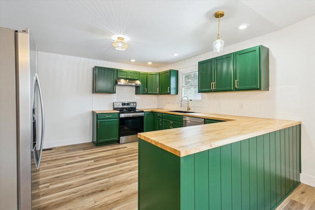 kitchen featuring light hardwood / wood-style flooring, wooden counters, green cabinets, hanging light fixtures, and stainless steel appliances