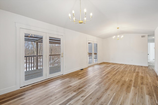 unfurnished living room with vaulted ceiling, light wood-type flooring, and an inviting chandelier