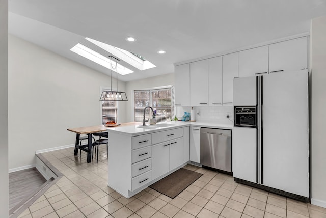 kitchen featuring white cabinetry, dishwasher, sink, hanging light fixtures, and white refrigerator with ice dispenser