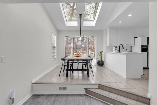 dining area with sink and a skylight