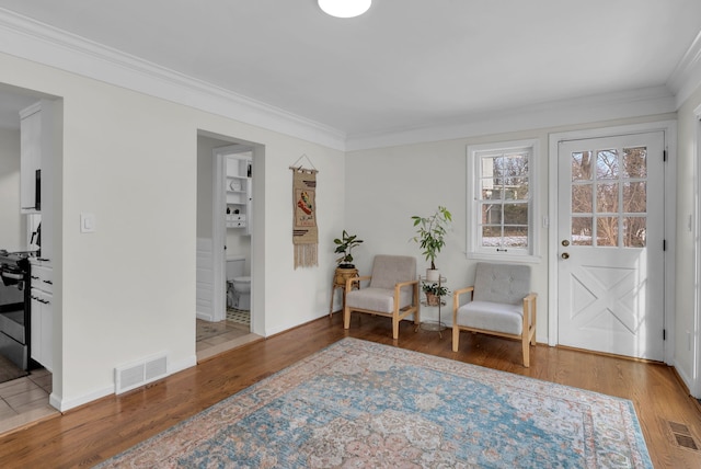 living area with crown molding and wood-type flooring