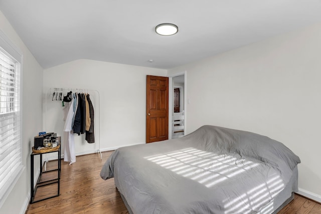 bedroom featuring wood-type flooring and vaulted ceiling