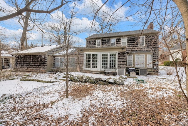 snow covered rear of property with cooling unit and french doors