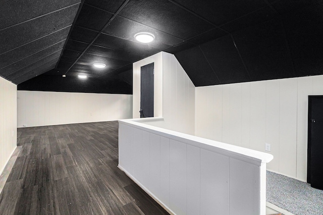 corridor featuring lofted ceiling, an upstairs landing, and wood finished floors