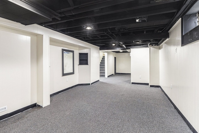 finished below grade area with carpet flooring, stairway, and baseboards