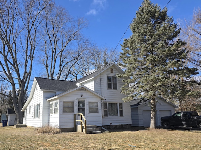 traditional-style house with a garage, a shingled roof, and a front lawn