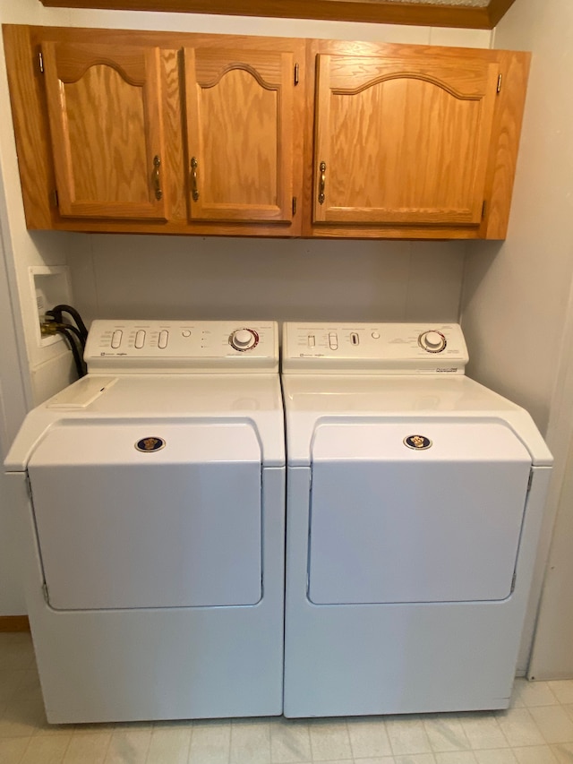 washroom featuring cabinets and washer and dryer