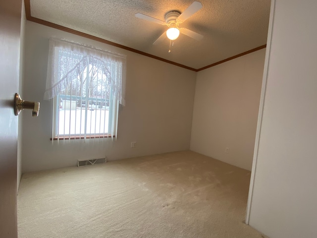 unfurnished room with crown molding, ceiling fan, carpet floors, and a textured ceiling