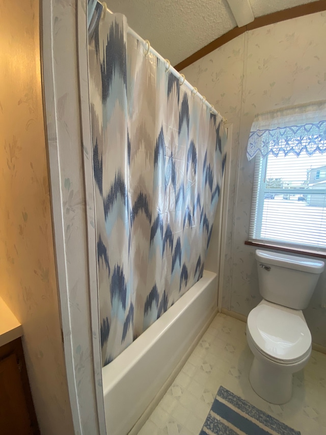 bathroom with shower / tub combo with curtain, a textured ceiling, and toilet