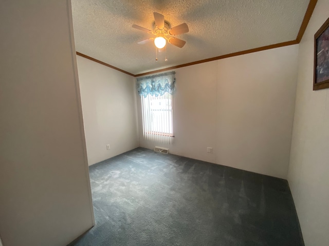 empty room featuring ornamental molding and a textured ceiling